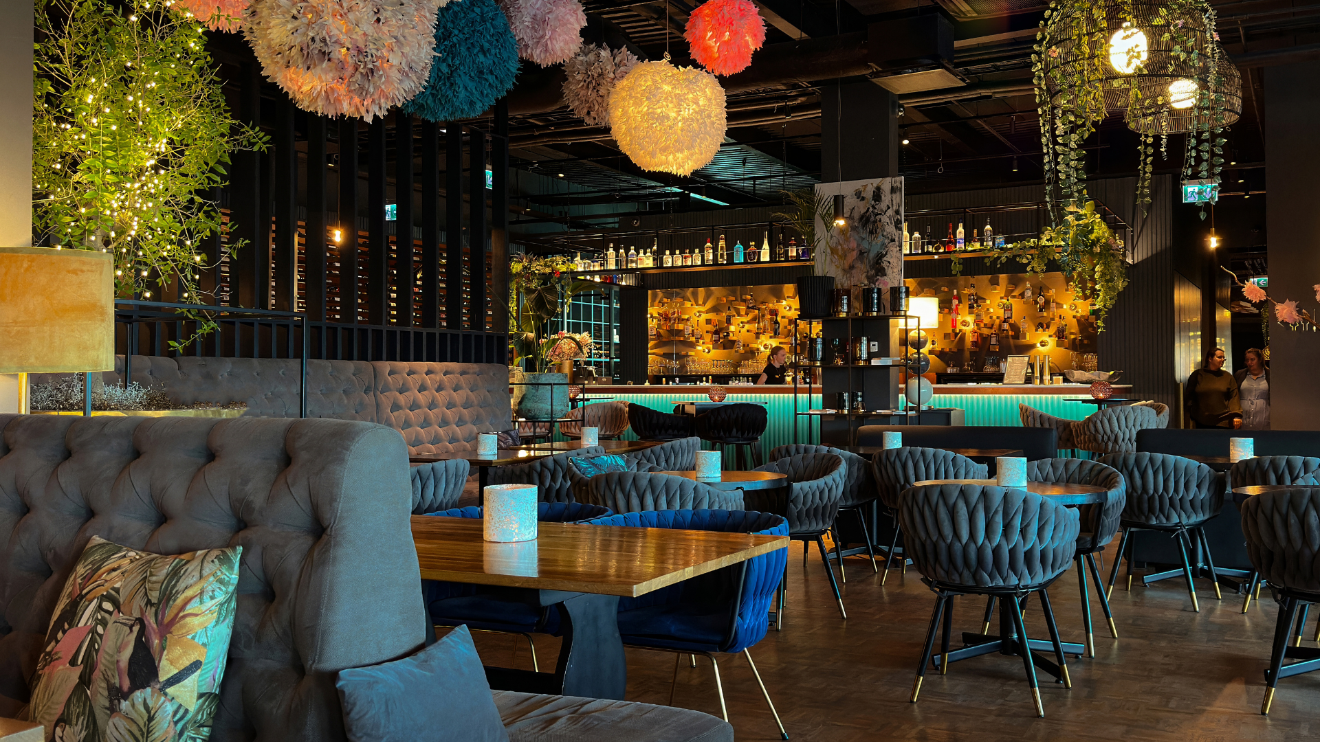 Interno di un ristorante con numerose luci colorate appese che creano un'atmosfera vivace e accogliente. 