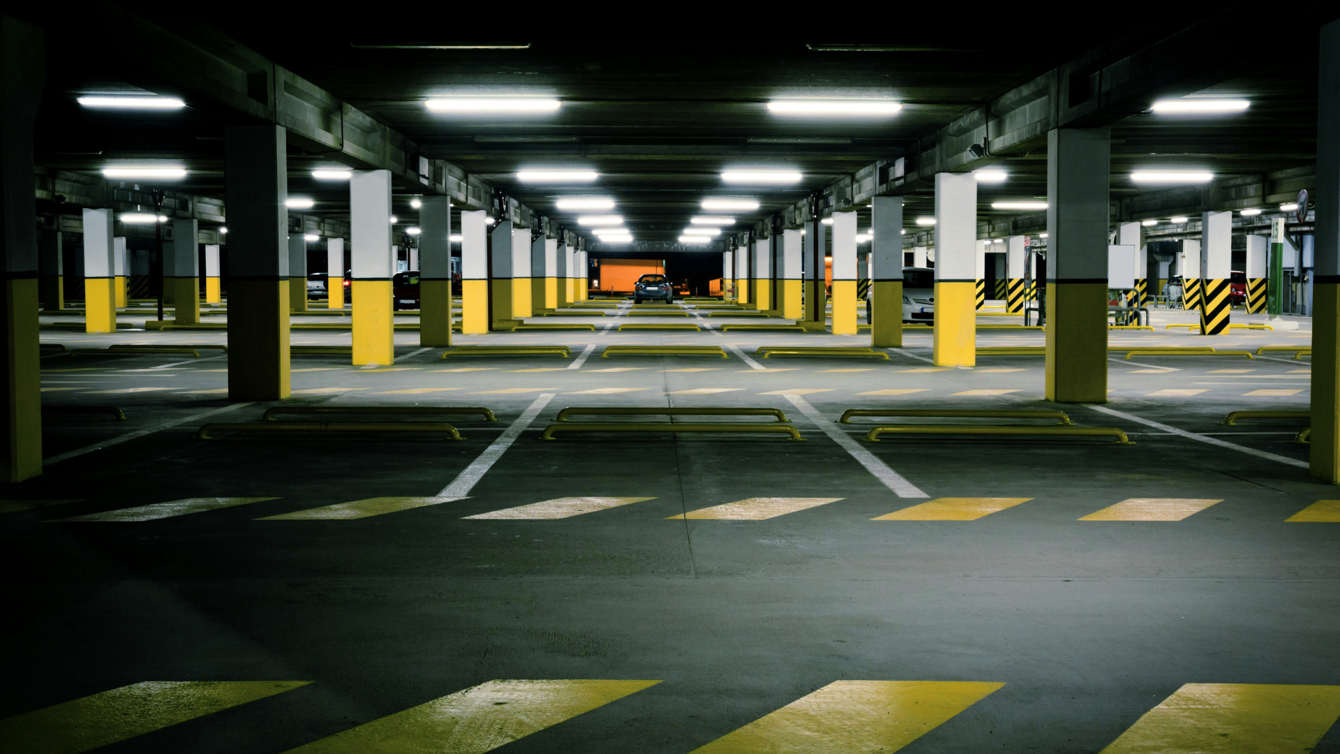 Area di parcheggio caratterizzata da strisce gialle e bianche, organizzata per la sosta dei veicoli.